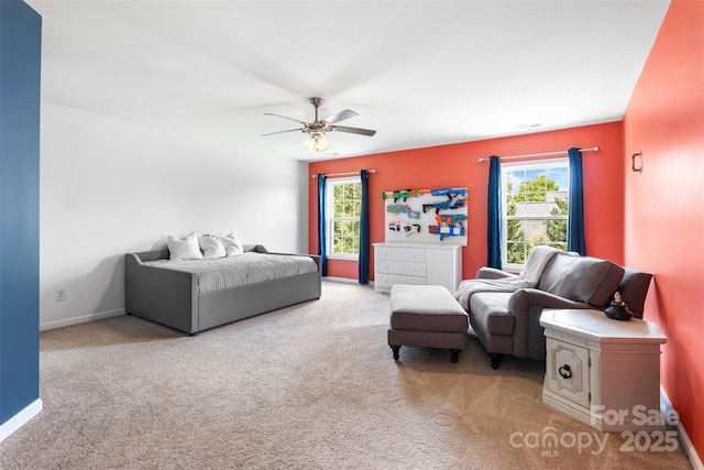 carpeted bedroom featuring baseboards and ceiling fan