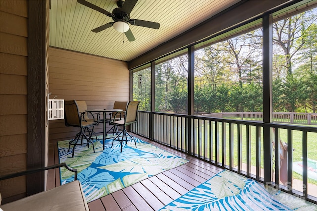 sunroom / solarium with a ceiling fan, outdoor dining space, and a healthy amount of sunlight