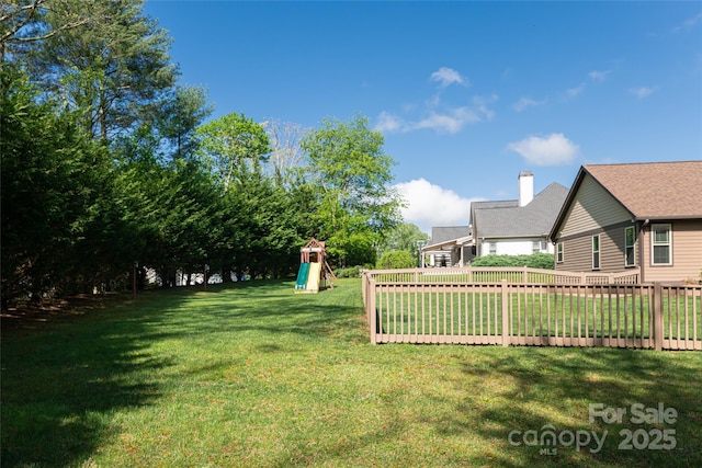 view of yard featuring a playground and fence