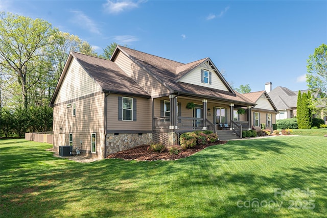 craftsman house featuring central air condition unit, covered porch, roof with shingles, and a front yard