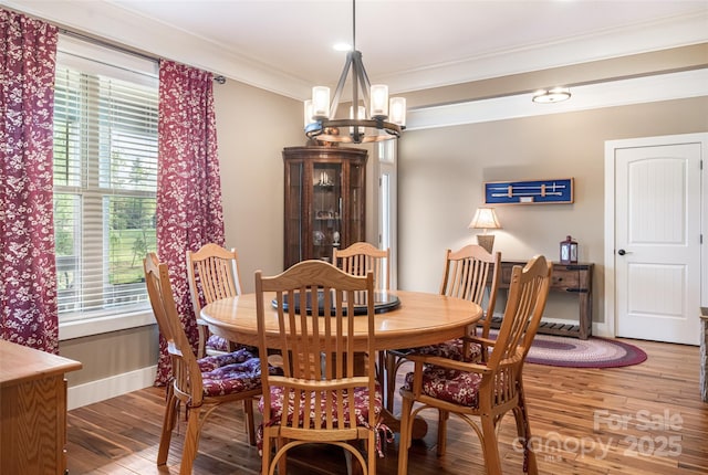 dining area featuring crown molding, a notable chandelier, a wealth of natural light, and wood finished floors