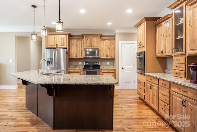 kitchen featuring a sink, ornamental molding, stainless steel appliances, and a kitchen breakfast bar