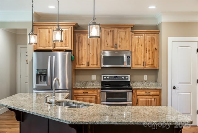 kitchen with crown molding, a kitchen breakfast bar, light wood-type flooring, a sink, and appliances with stainless steel finishes