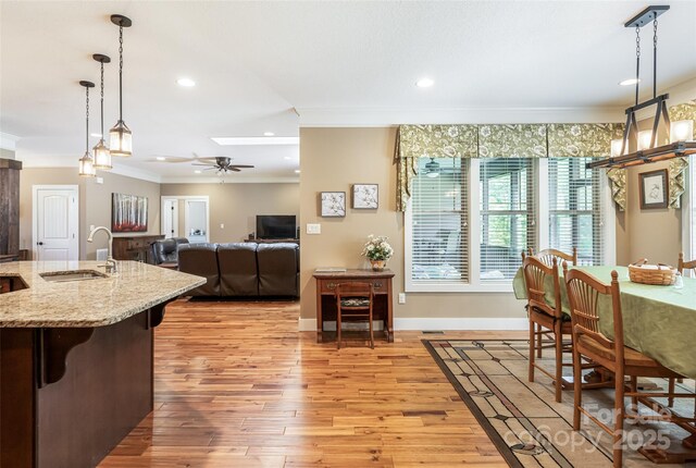 dining area featuring crown molding, a ceiling fan, baseboards, recessed lighting, and light wood-type flooring