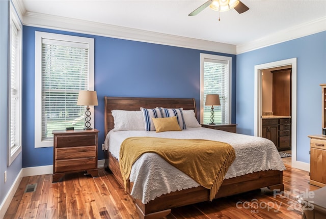 bedroom with crown molding, baseboards, visible vents, and wood-type flooring