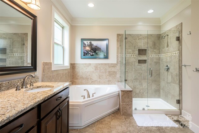 full bath featuring a bath, tile walls, a stall shower, vanity, and ornamental molding