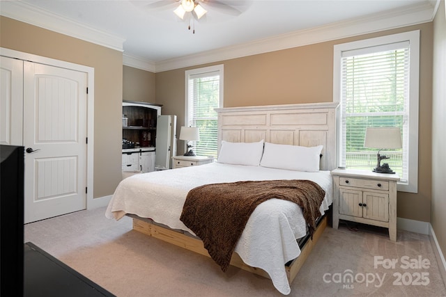 bedroom featuring light colored carpet, a ceiling fan, baseboards, and crown molding