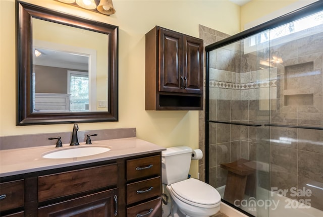 bathroom featuring vanity, a stall shower, and toilet