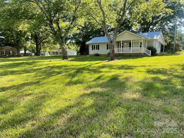 view of grassy yard featuring covered porch