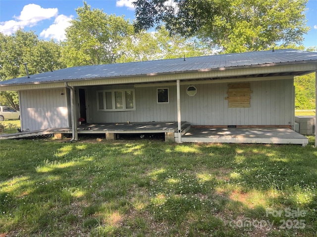 rear view of property with a lawn, metal roof, and a porch