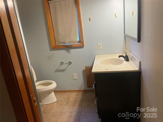 bathroom with tile patterned floors, vanity, baseboards, and toilet