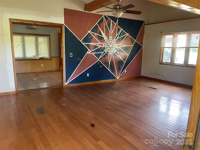 unfurnished room with a ceiling fan, hardwood / wood-style flooring, baseboards, and vaulted ceiling