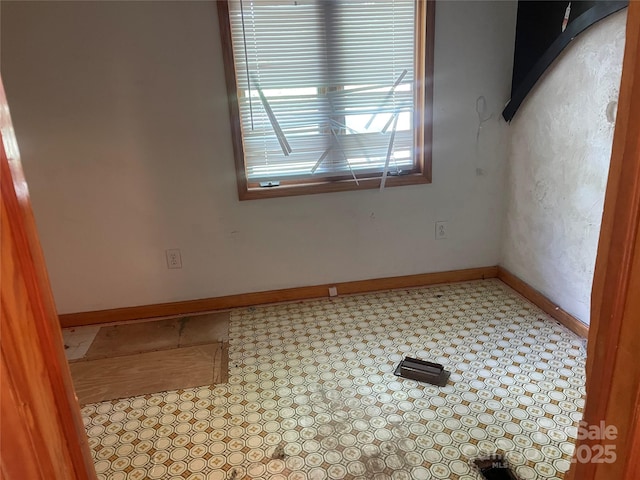 spare room with baseboards