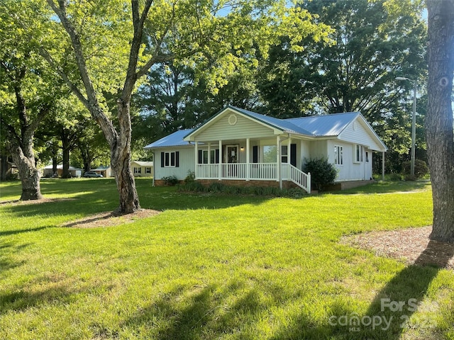 single story home featuring a porch, a front yard, and metal roof