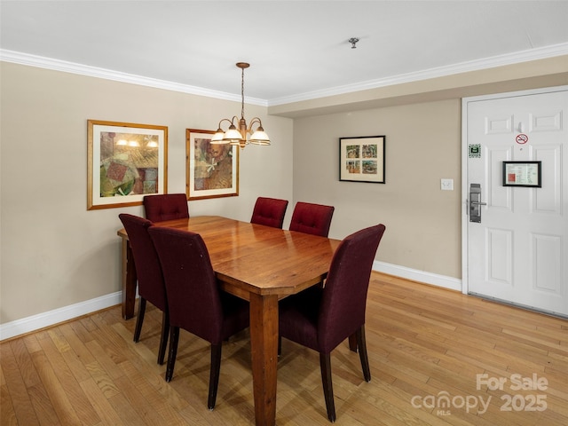 401 Bowling Park Rd, Asheville, NC 28803 - dining space with light wood-type flooring, crown molding, a chandelier, and baseboards