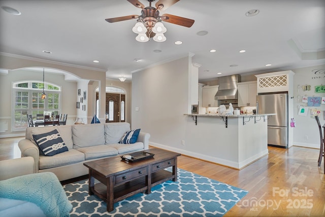 7471 Barfield Ln, Denver, NC 28037 - living room featuring arched walkways, ceiling fan, ornamental molding, light wood-type flooring, and recessed lighting