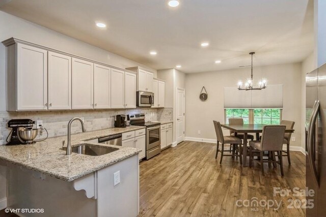 876 Hardin St Unit B24, Lancaster, SC 29720 - kitchen featuring stainless steel appliances, decorative backsplash, light stone counters, baseboards, and a sink