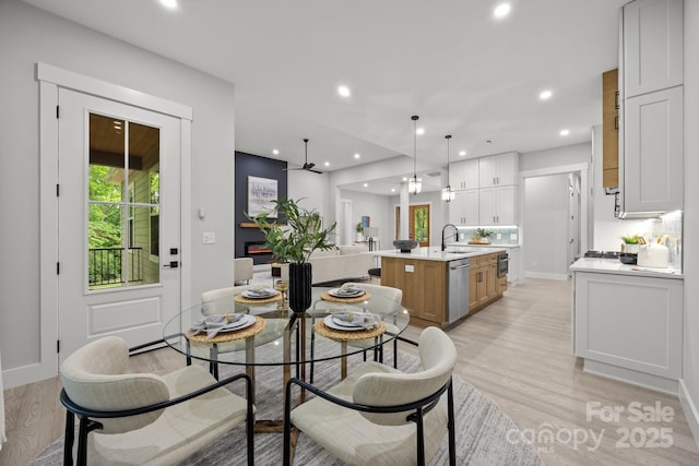 dining room featuring ceiling fan, recessed lighting, light wood-style flooring, and baseboards