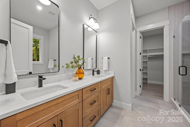 bathroom featuring double vanity, visible vents, a shower stall, and a sink