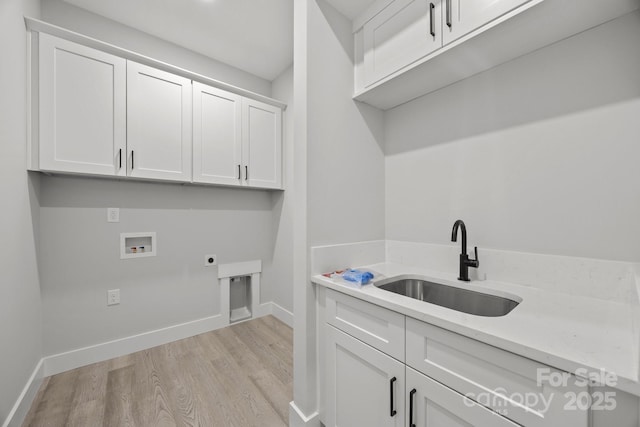 laundry room featuring a sink, cabinet space, washer hookup, electric dryer hookup, and light wood-style flooring