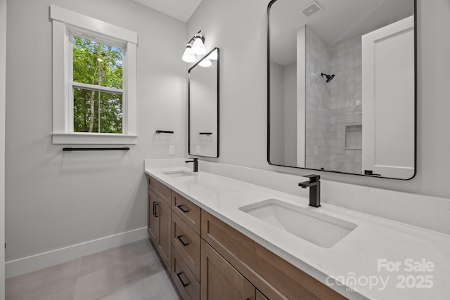 bathroom featuring baseboards, visible vents, double vanity, and a sink