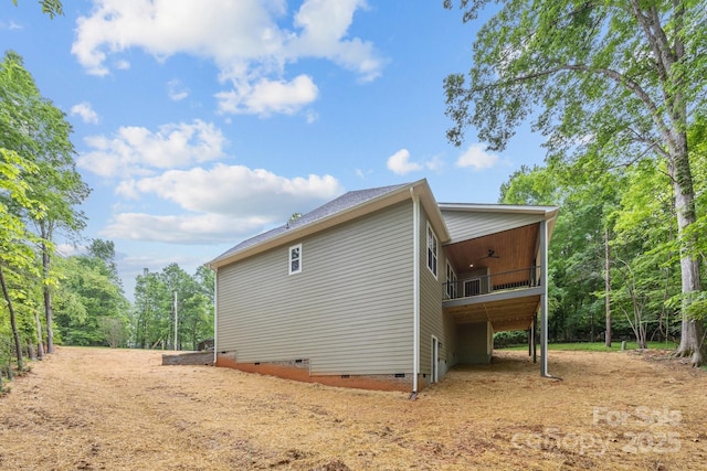 view of side of property featuring ceiling fan, dirt driveway, and crawl space