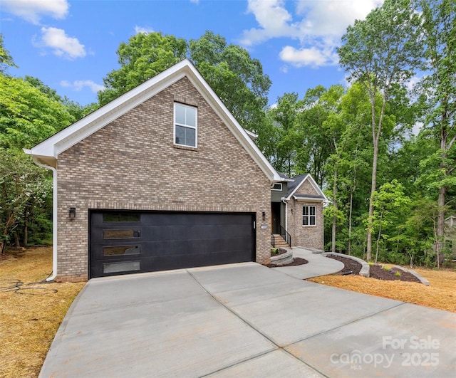 view of front of house with driveway, brick siding, and a garage