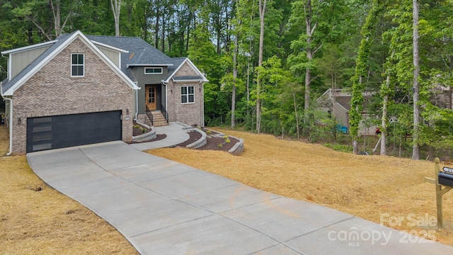 view of front of house featuring roof with shingles, concrete driveway, brick siding, and a garage