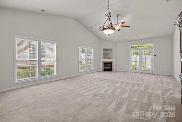 8313 Carob Tree Ln, Charlotte, NC 28215 - unfurnished living room with light carpet, a glass covered fireplace, built in shelves, baseboards, and high vaulted ceiling