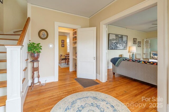 interior space featuring light wood-type flooring, baseboards, and ornamental molding