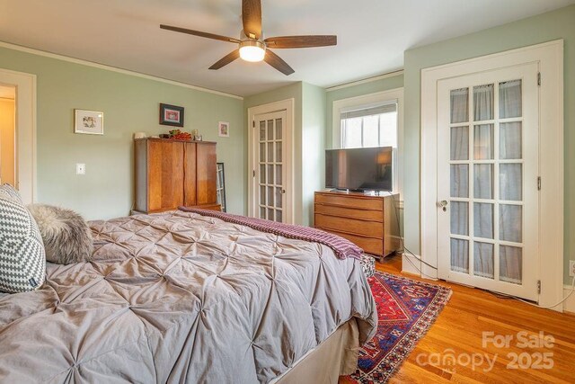 bedroom featuring light wood-style flooring, ornamental molding, and ceiling fan