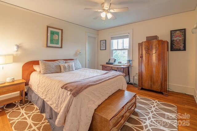 bedroom with wood finished floors, a ceiling fan, and baseboards