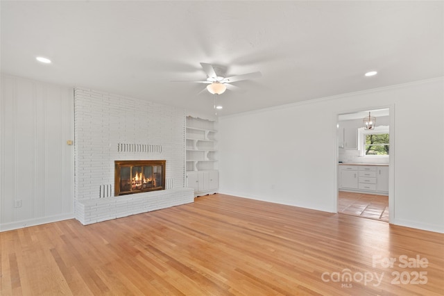 1294 Beaverdam Rd, Canton, NC 28716 - unfurnished living room with ceiling fan, a brick fireplace, light wood-type flooring, and built in shelves