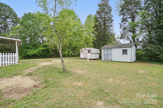 410 E 17th St, Kannapolis, NC 28083 - view of yard featuring fence, a storage unit, and an outdoor structure