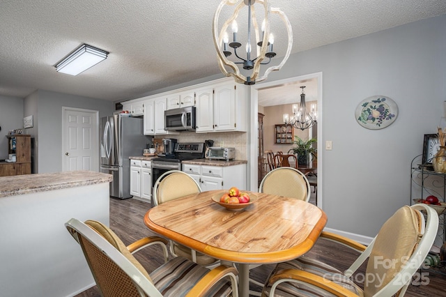 118 Sir Gregory Dr, Shelby, NC 28152 - dining room featuring a textured ceiling, a toaster, baseboards, dark wood-style floors, and a notable chandelier