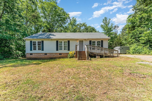 ranch-style home featuring crawl space, a wooden deck, and a front yard