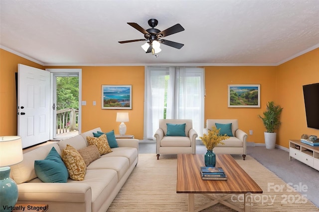 carpeted living room featuring a ceiling fan, ornamental molding, and baseboards