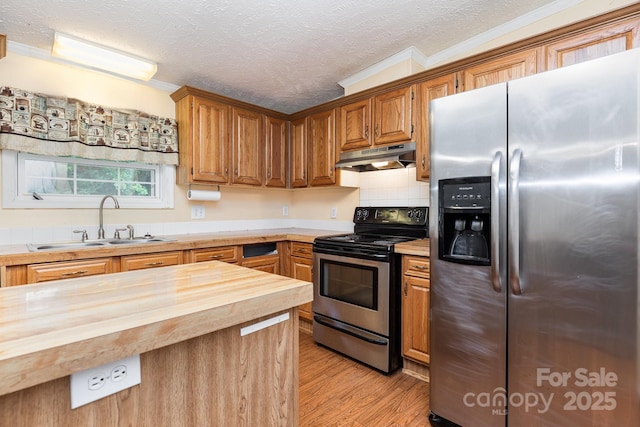 kitchen featuring stainless steel appliances, wooden counters, under cabinet range hood, a sink, and crown molding