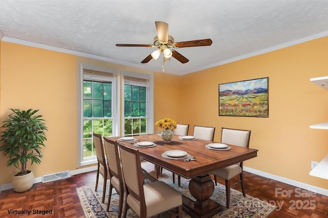 dining room with crown molding, baseboards, a ceiling fan, and visible vents