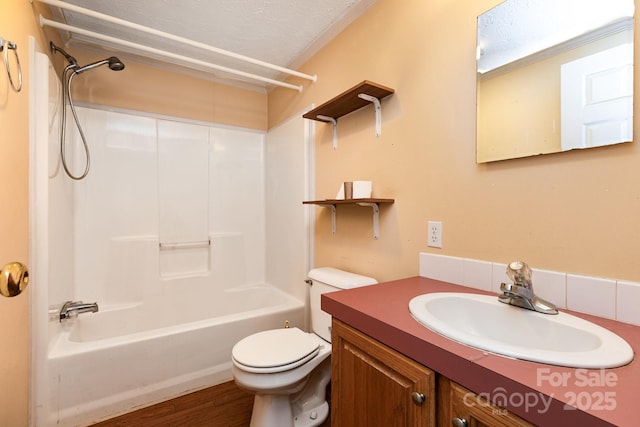 full bathroom featuring toilet, bathing tub / shower combination, vanity, a textured ceiling, and wood finished floors