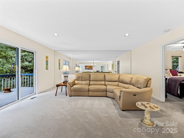 living room featuring baseboards, light carpet, ceiling fan, and recessed lighting