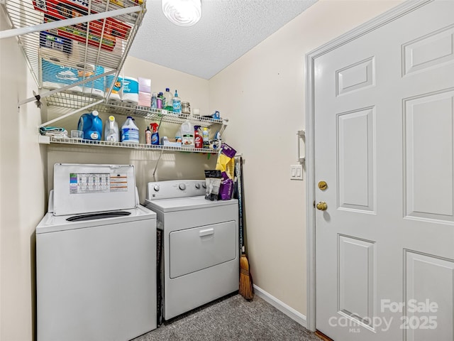 clothes washing area featuring washer and clothes dryer, a textured ceiling, carpet floors, baseboards, and laundry area