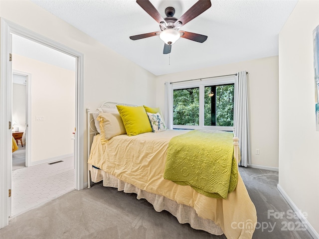 carpeted bedroom with baseboards, a ceiling fan, a textured ceiling, and visible vents