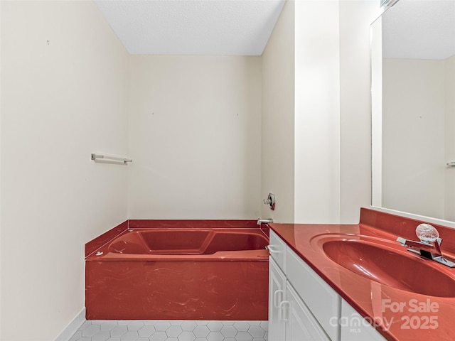 full bath with a bath, vanity, and a textured ceiling