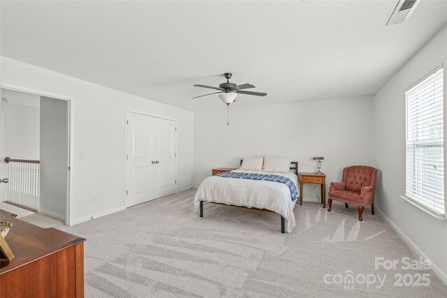 carpeted bedroom featuring baseboards, visible vents, and ceiling fan