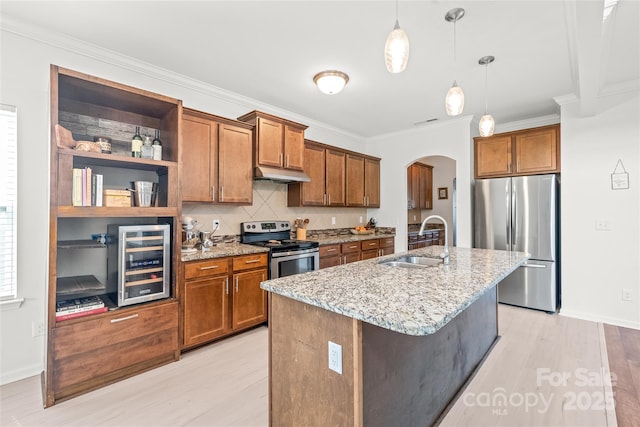 306 Fesperman Cir, Troutman, NC 28166 - kitchen with appliances with stainless steel finishes, wine cooler, arched walkways, brown cabinets, and ornamental molding