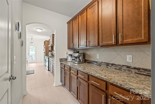 306 Fesperman Cir, Troutman, NC 28166 - kitchen with arched walkways, tasteful backsplash, electric range oven, and light stone countertops