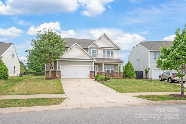 306 Fesperman Cir, Troutman, NC 28166 - craftsman house with a porch, concrete driveway, an attached garage, a shingled roof, and stone siding