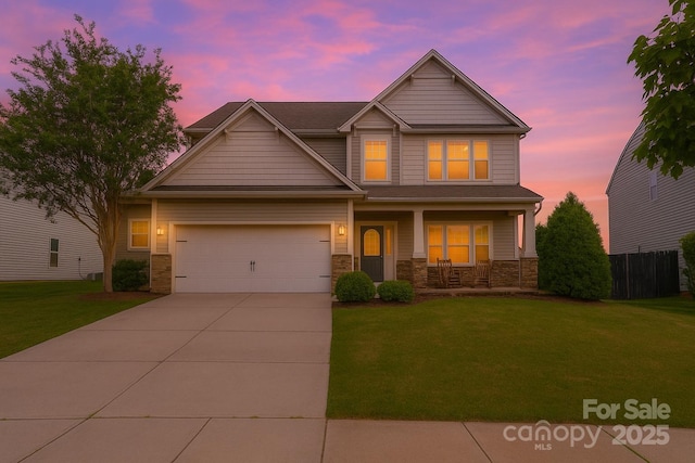 306 Fesperman Cir, Troutman, NC 28166 - craftsman-style home with a porch, driveway, a garage, and stone siding