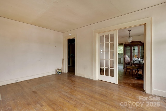 empty room with baseboards and wood finished floors